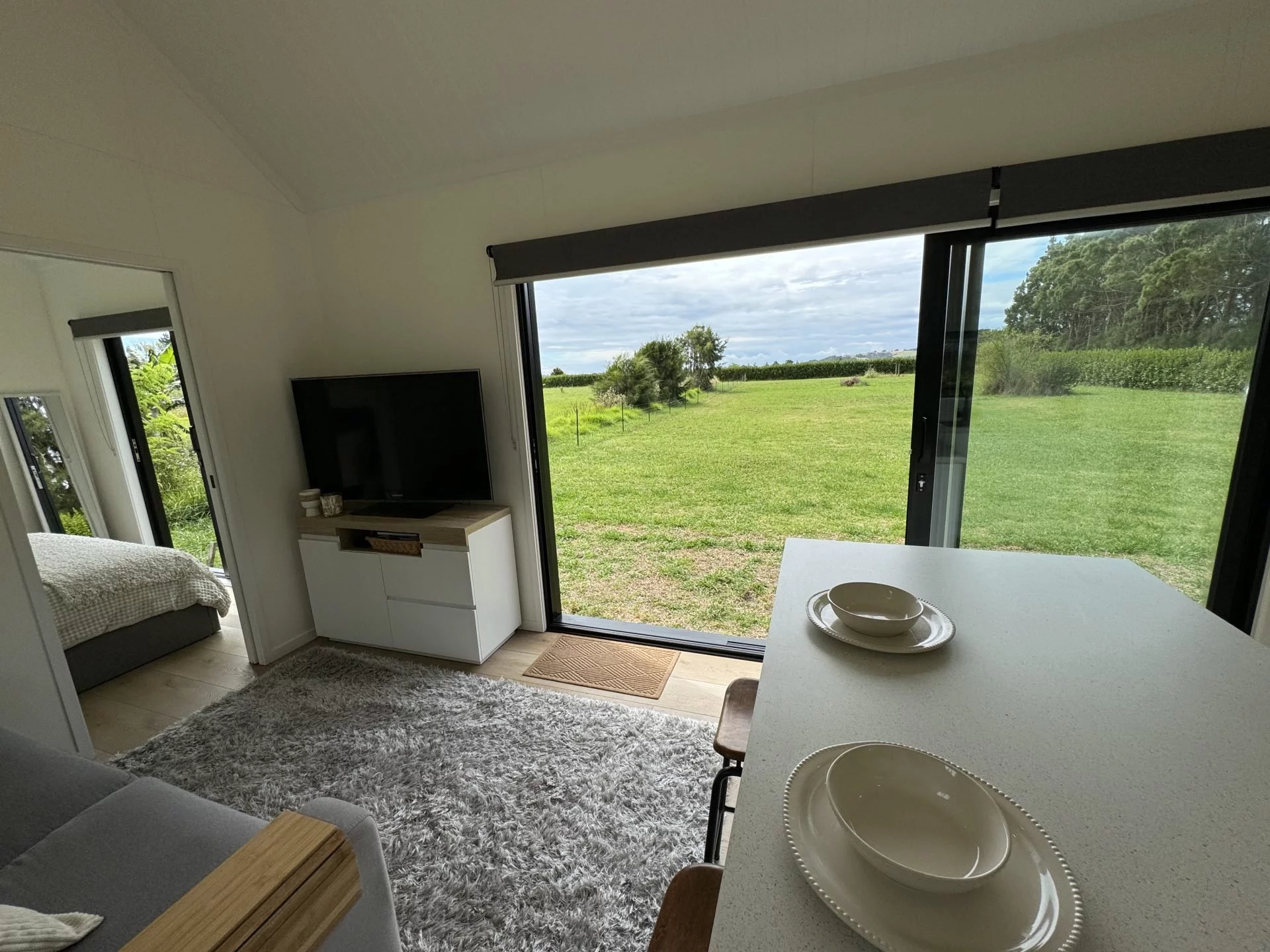 The living room in the Long Black (with loft) features a sofa and a TV, plus a little storage space