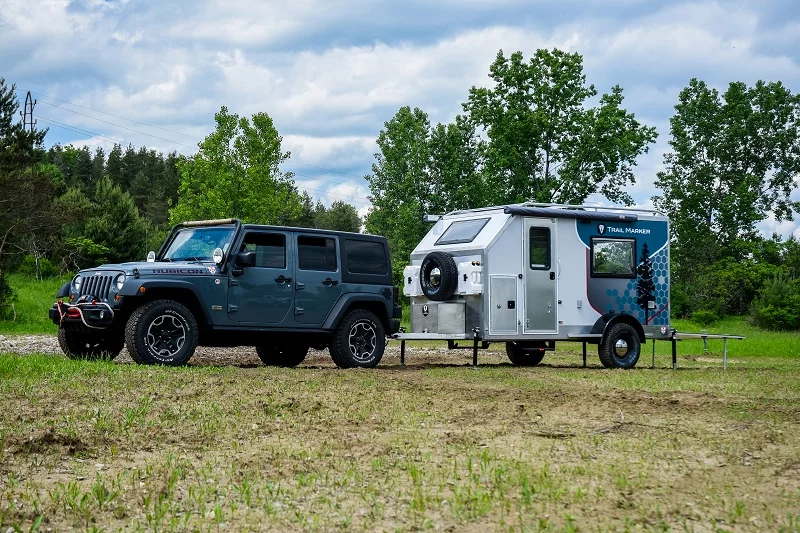 A Jeep Wrangler Unlimited tows the Trail Marker Sequoia to camp