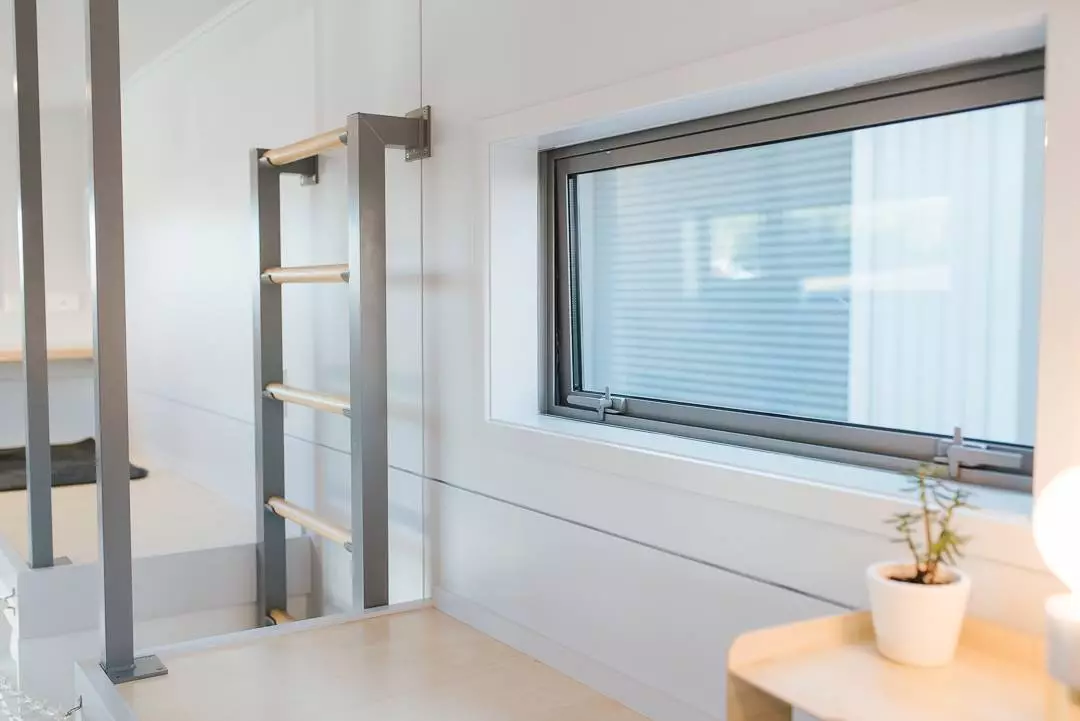 The Larissa and Tyler Tiny House's loft is accessed by wall-mounted ladder