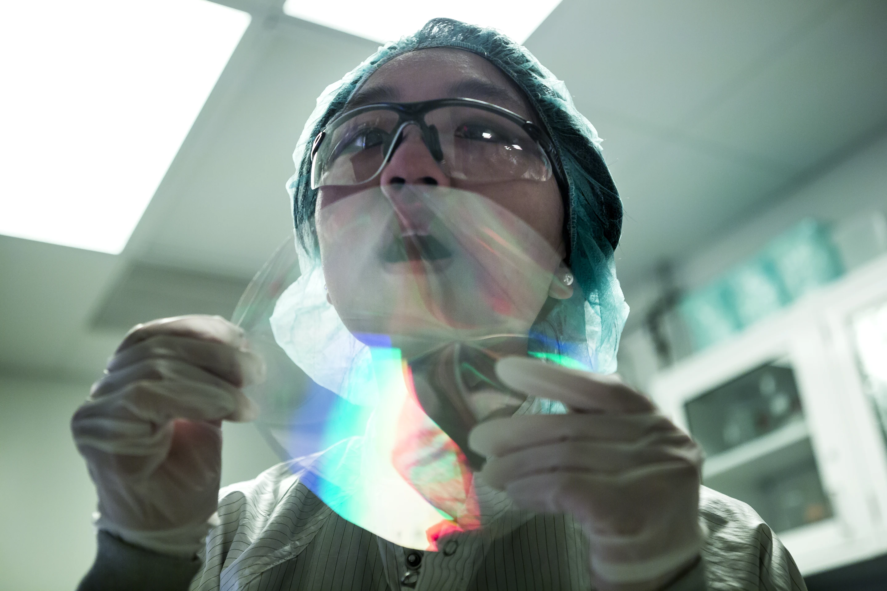 A researcher breathes on a nanomaterial printed to reveal a hidden image