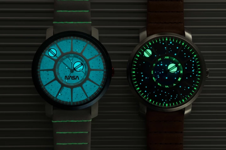 The Saturn V (left) and I.S.S. (right) models at night, demonstrating the luminous hands and star map dial, and the perpetually glowing, tritium gas-filled glass tubes (automatic version only) at the ends of the hour and minute hands