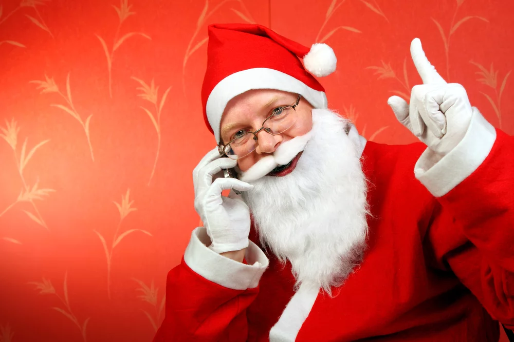 You can call Santa and leave a message, or have him send a personalized call to a loved one (Santa with phone via Shutterstock)