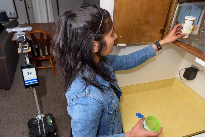 The robot assists master's student Nisha Raghunath in a medication-taking task