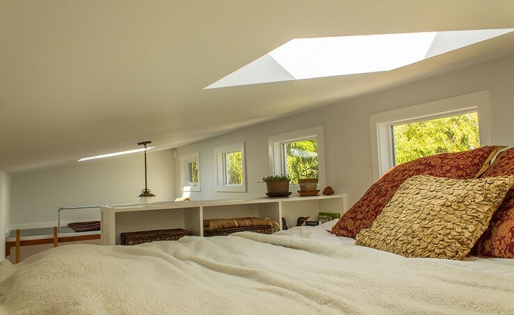 The master loft features a queen bed and a bank of built-in storage shelves