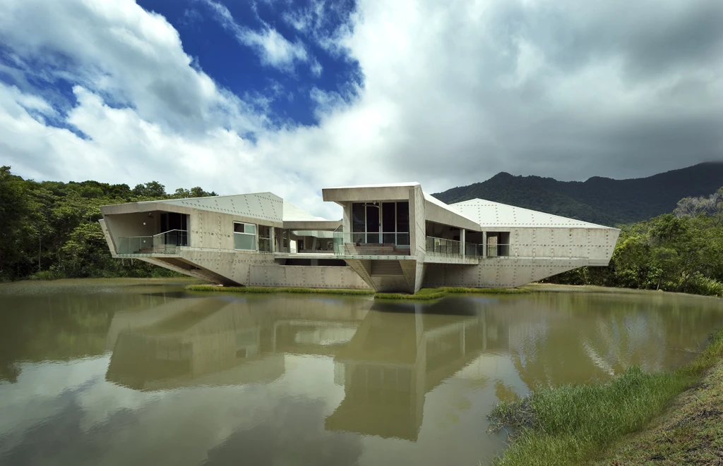 Constructed on a small patch of land in the middle of a pond, much of the Stamp House is comprised of a mixture of new and used concrete, which provides insulation to keep the temperature more constant throughout the year
