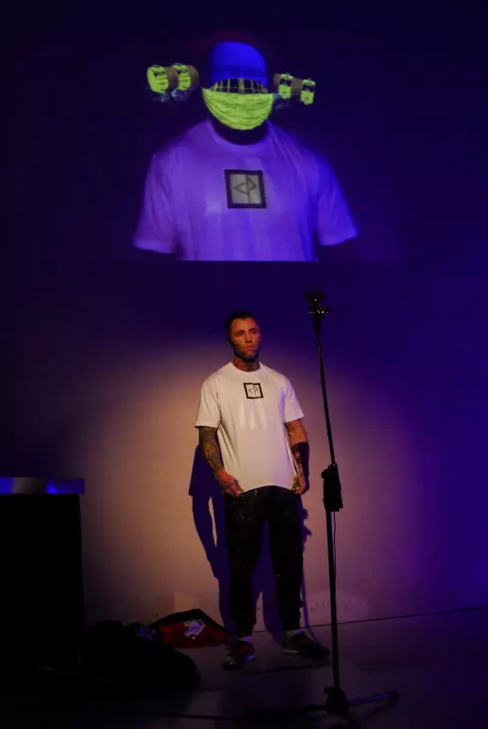 A webcam is front of the model reads the symbol on the t-shirt which triggers the CGI animations behind him