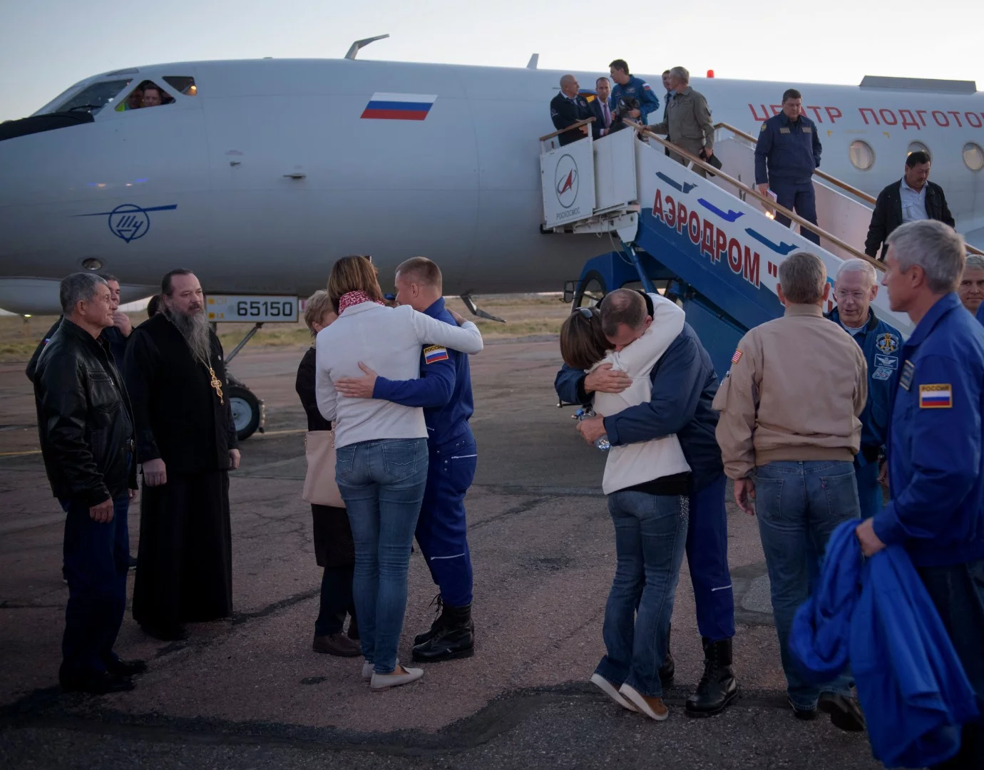 Expedition 57 Flight Engineer Alexey Ovchinin of Roscosmos, left, and Flight Engineer Nick Hague of NASA, right. embrace their families after landing at the Krayniy Airport,