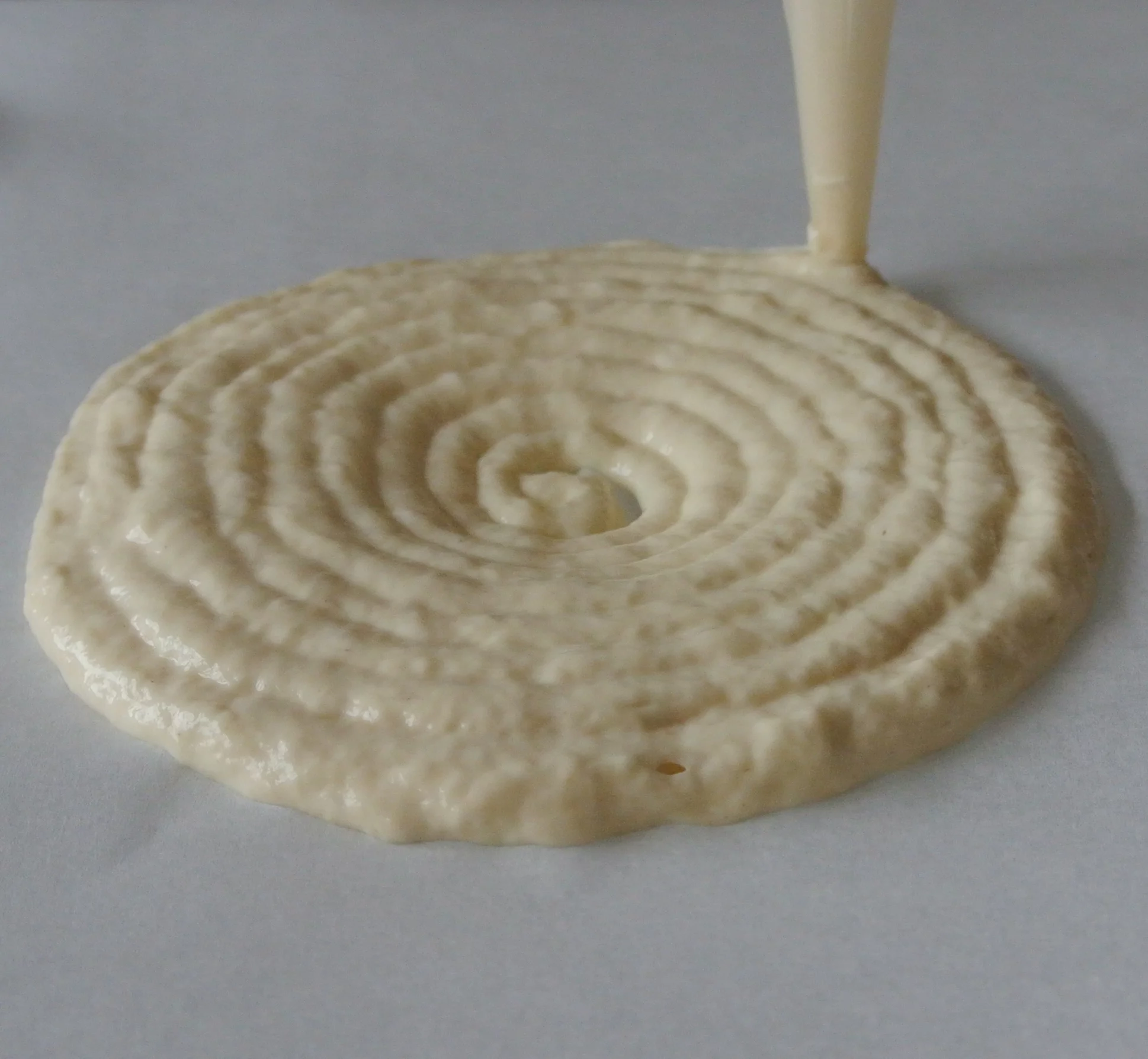 Foodini creates pizza by extruding dough into a spiral shape