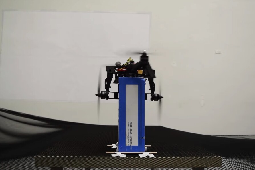 By folding down two of its arms, the Midair Reconfigurable Quadcopter is able to grasp and lift a box