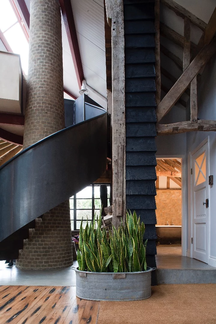 The mezzanine is accessed by a steel staircase that cantilevers from a tapered brick chimney