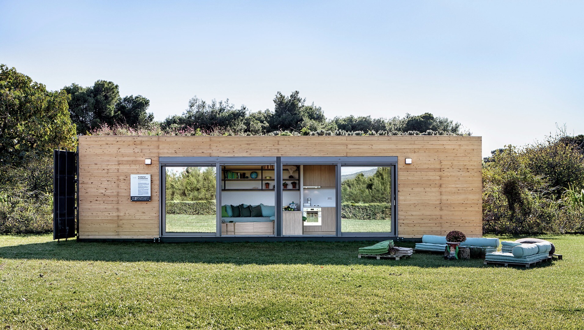 Stylish shipping container house is topped by a green roof