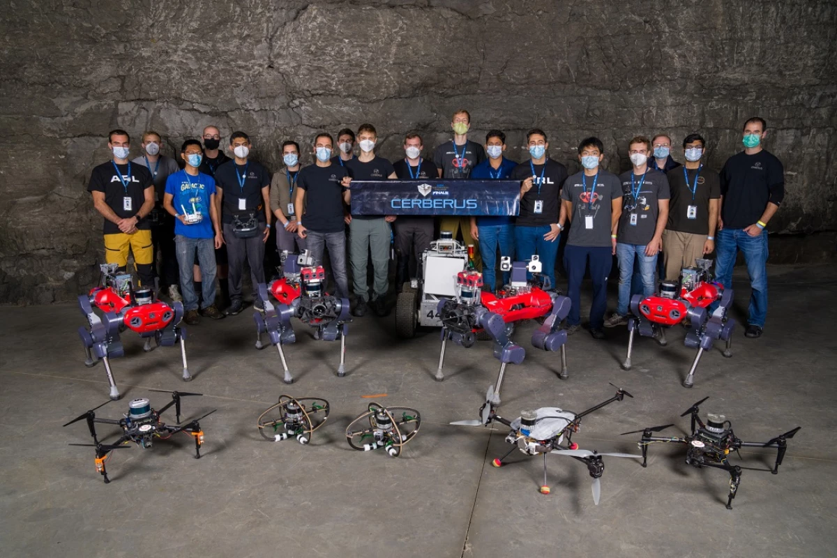 The Team CERBERUS members with their multicopter drones and ANYmal C quadruped robots