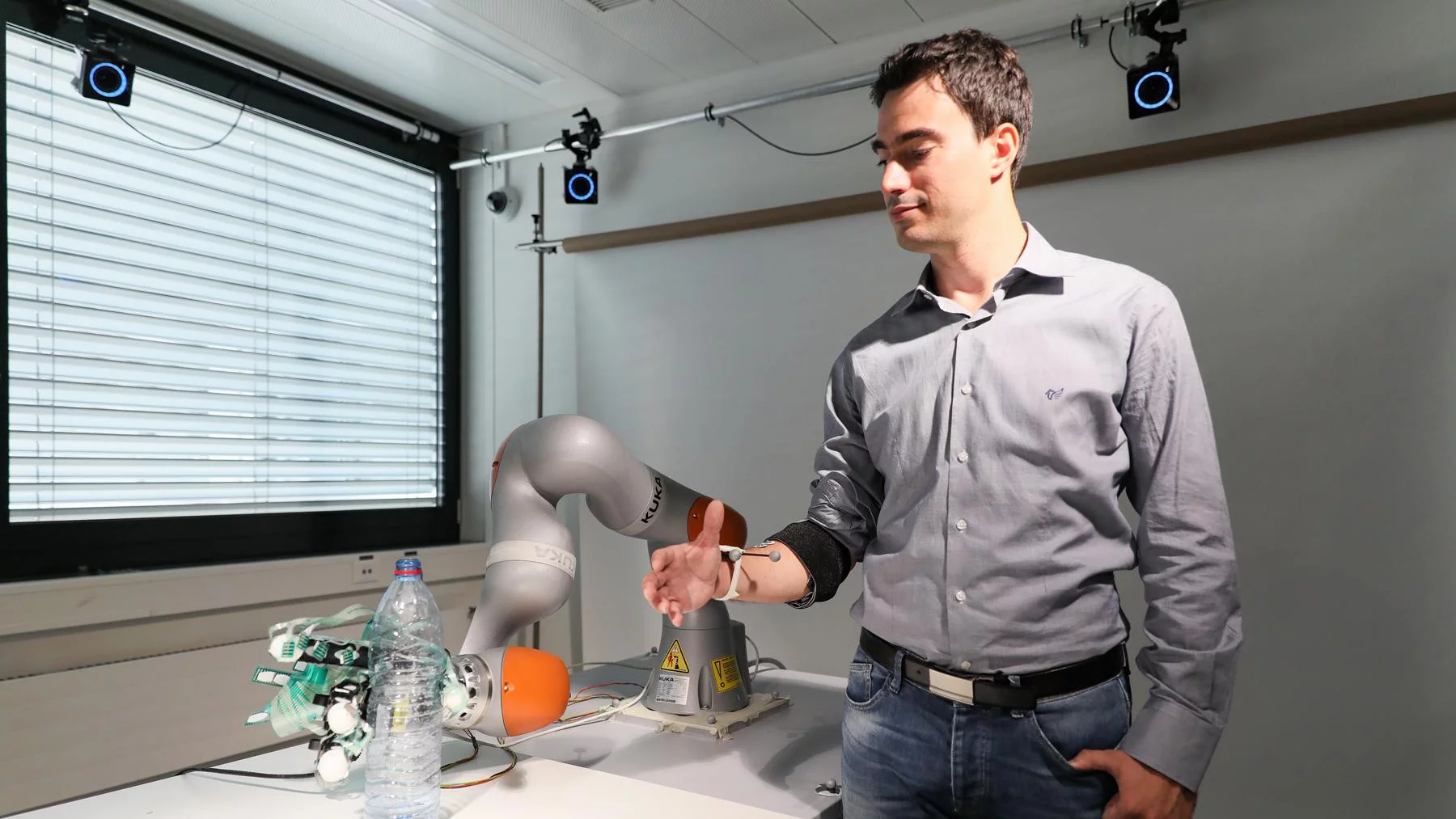 Researcher Artoni Fiorenzo demonstrates the shared control system, using a robotic arm