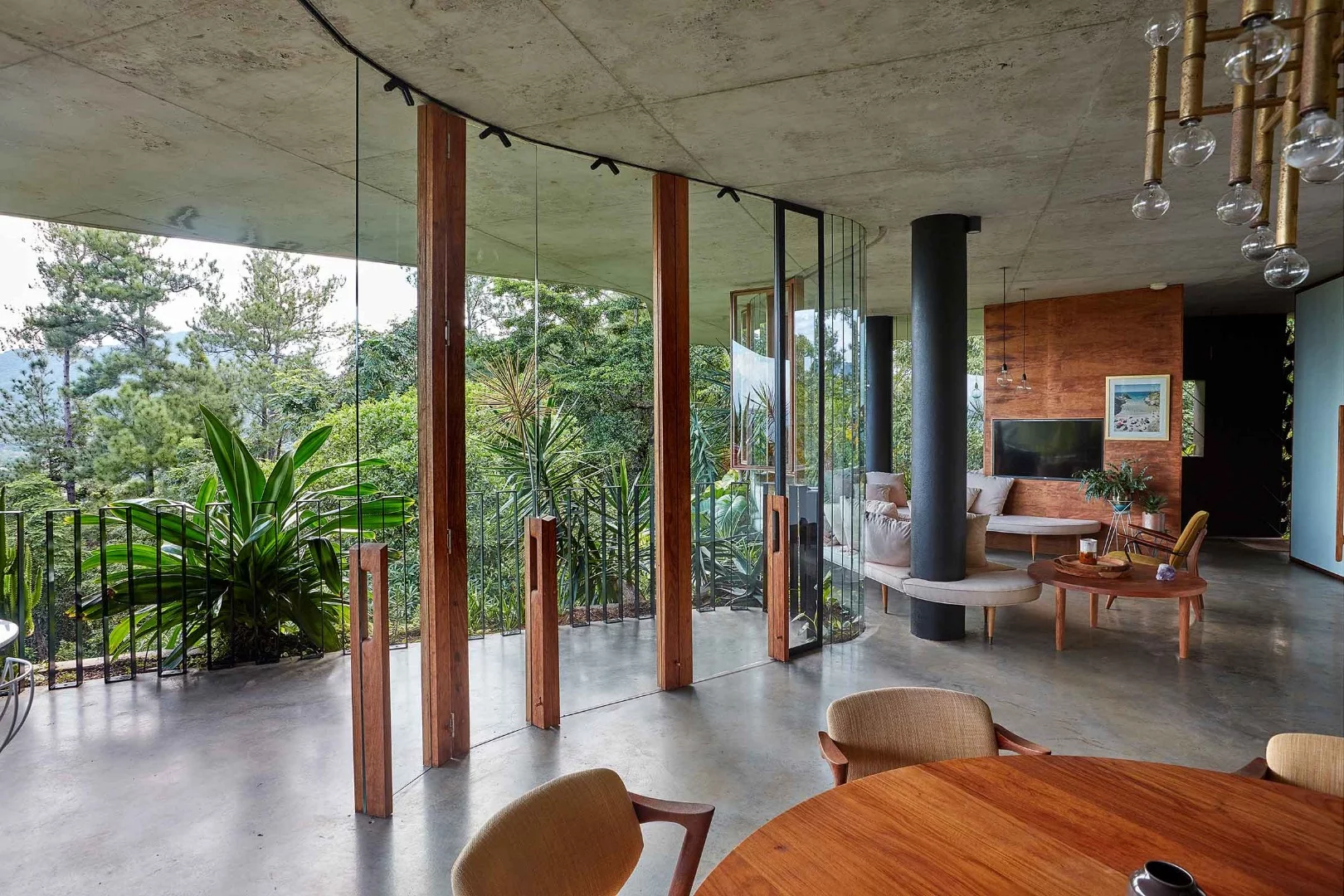 The Planchonella House uses the combination of greenery-covered roof, large sliding windows and concrete thermal mass to passively cool its interior