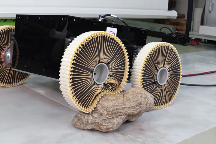 The adaptable wheels in action, rolling over a large rock with ease