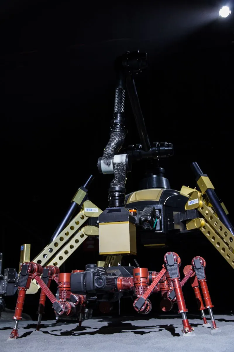 SHERPA is using its manipulator arm to equip CREX with an additional payload-item