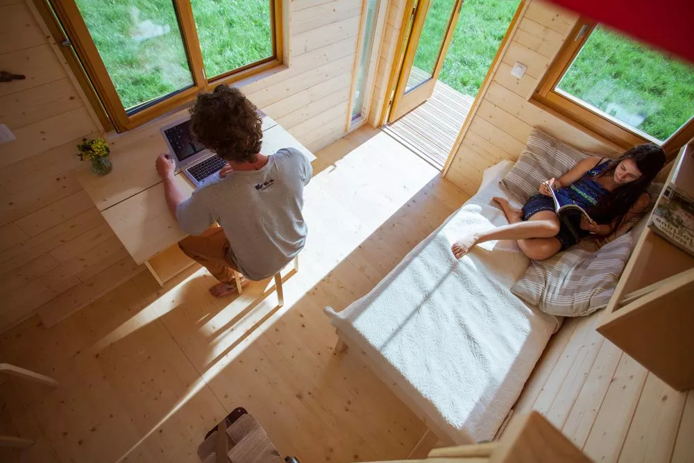 Visitors to La Tête dans les étoiles are greeted with a living area that contains a folding office desk and a daybed