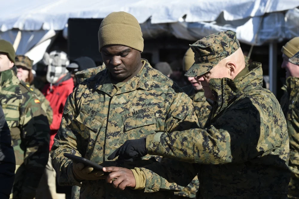 Sgt. Dionte Jones demonstrates to the Commandant of the Marine Corps, Gen. Robert B. Neller, how he uses a handheld tablet to request resupply from a UH-1 Huey equipped with AACUS