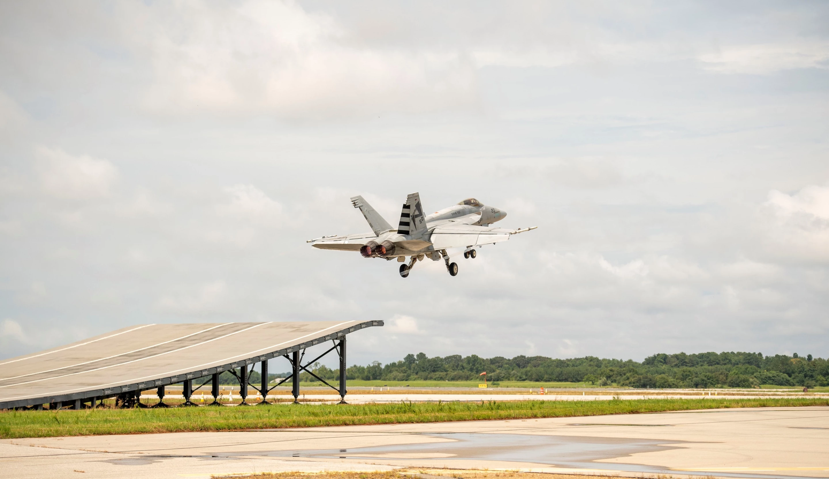 A F/A-18 Super Hornet taking off from ski-jump ramp for the first time