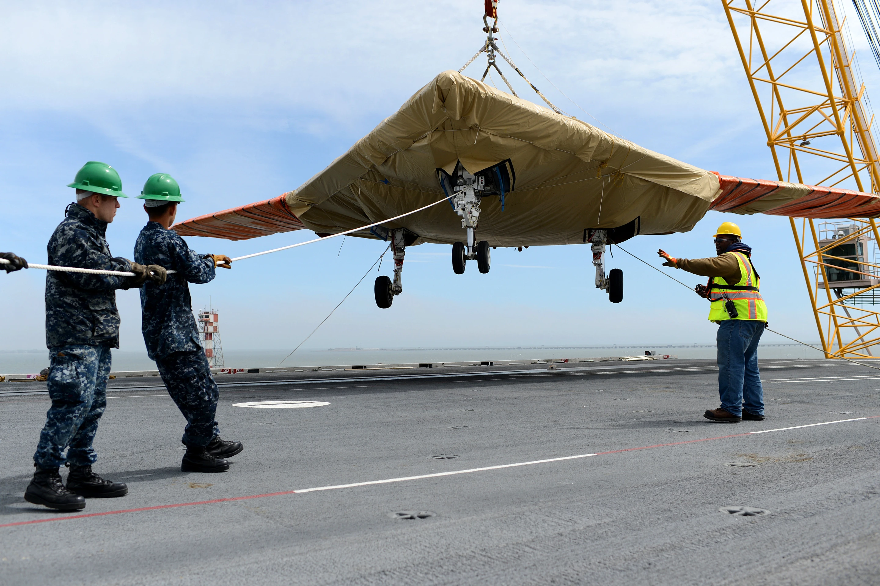 An X-47B Unmanned Combat Air System (UCAS) demonstrator is loaded onto the flight deck of the aircraft carrier USS George H.W. Bush (CVN 77) (Photo: US. Navy/Mass Communication Specialist 2nd Class Tony D. Curtis)