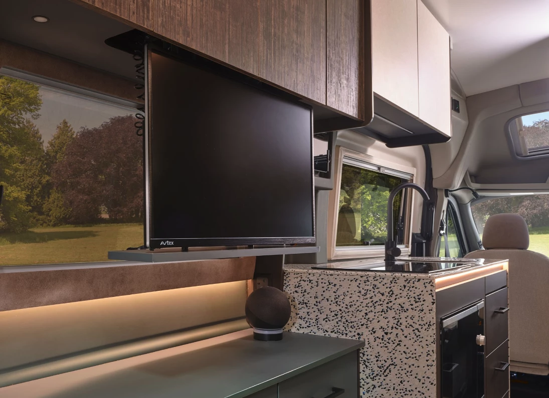 The TV uses an electric lift system to retract away when not in use, freeing space and clearing the view out the rear window
