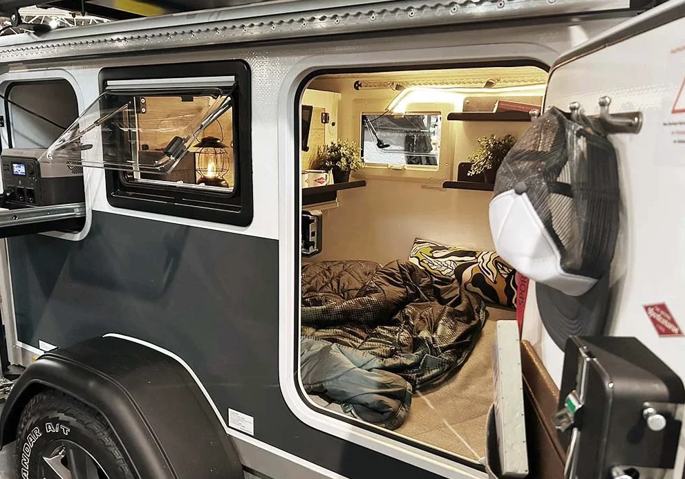 A look inside the teardrop-like cabin of the Sportcaravan Cube 1; also note the slide-out in the upper outdoor cabinet next to the window