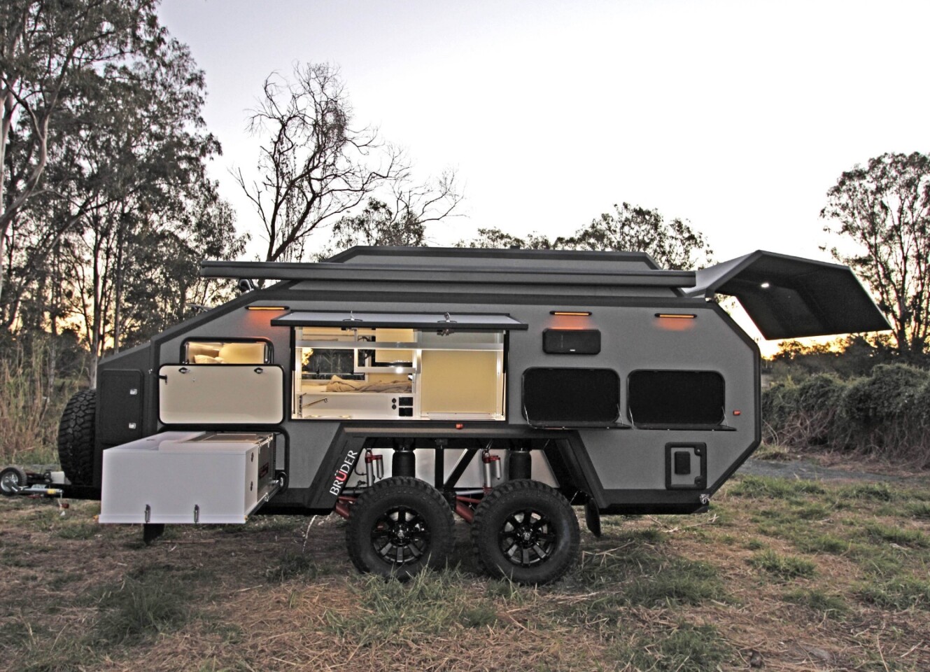 The side panel door provides access to the indoor/outdoor kitchen, while the slide-out completes the outdoor kitchen space with a fridge/freezer, worktop and storage