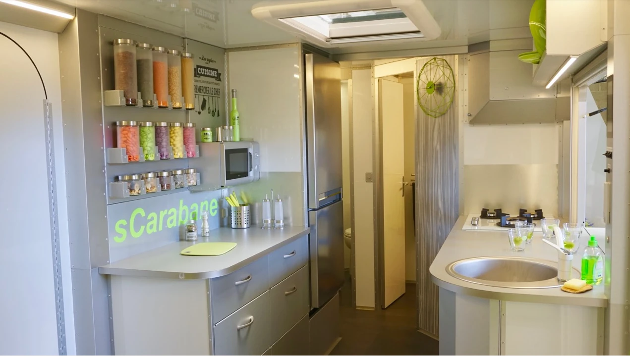 The sCarabane has a large kitchen area with stove, sink, refrigerator, microwave and even dishwasher