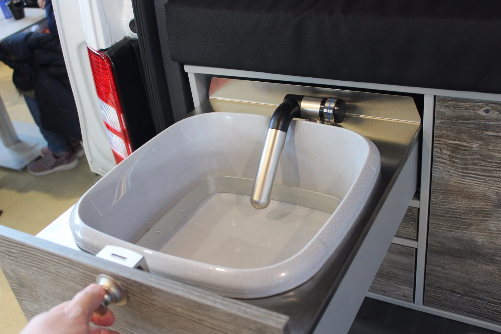 VanEssa puts the bed up atop a rear cabinet with slide-out sink, stove and fridge