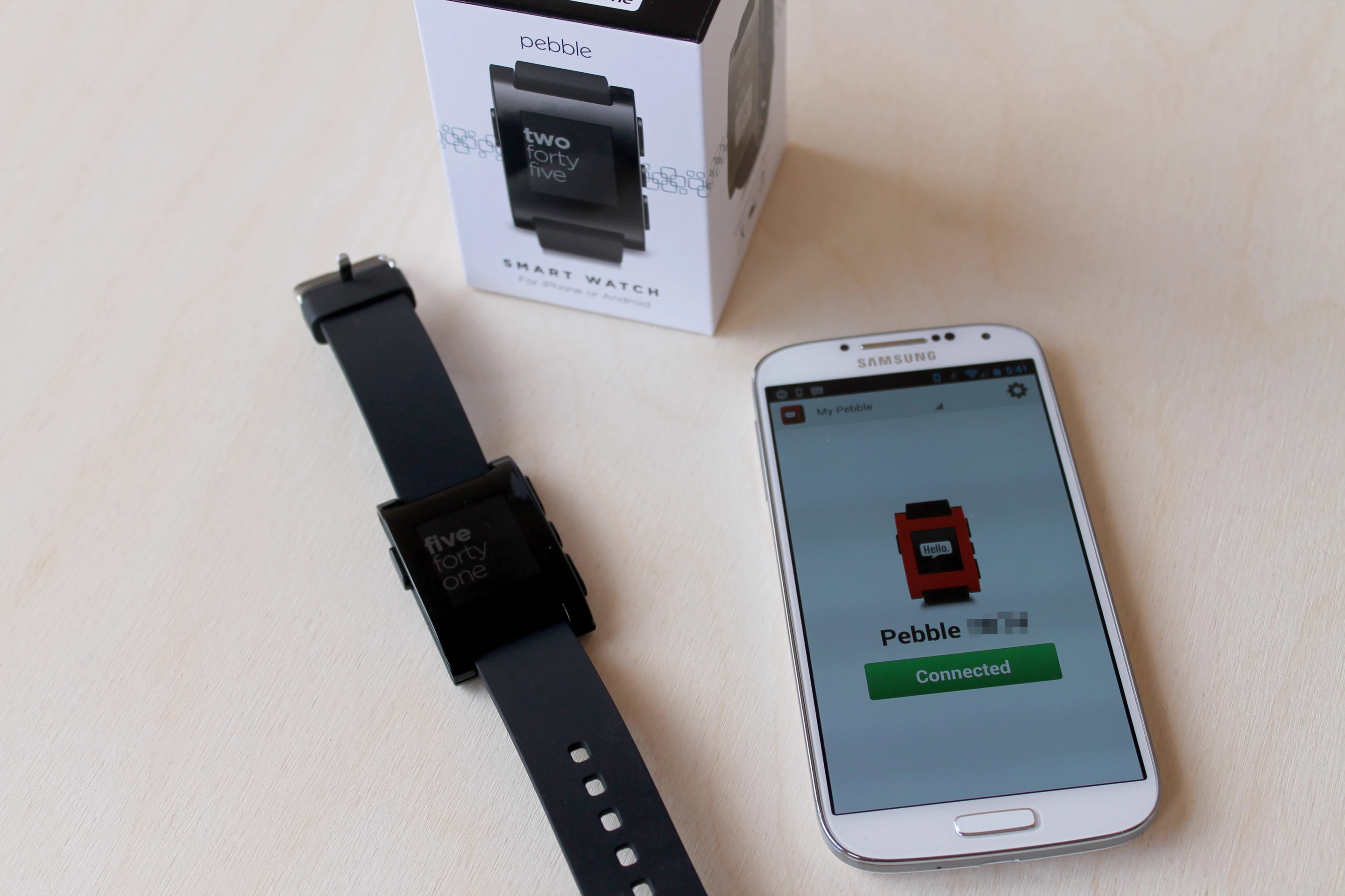 Pebble with retail packaging and a synced Galaxy S4