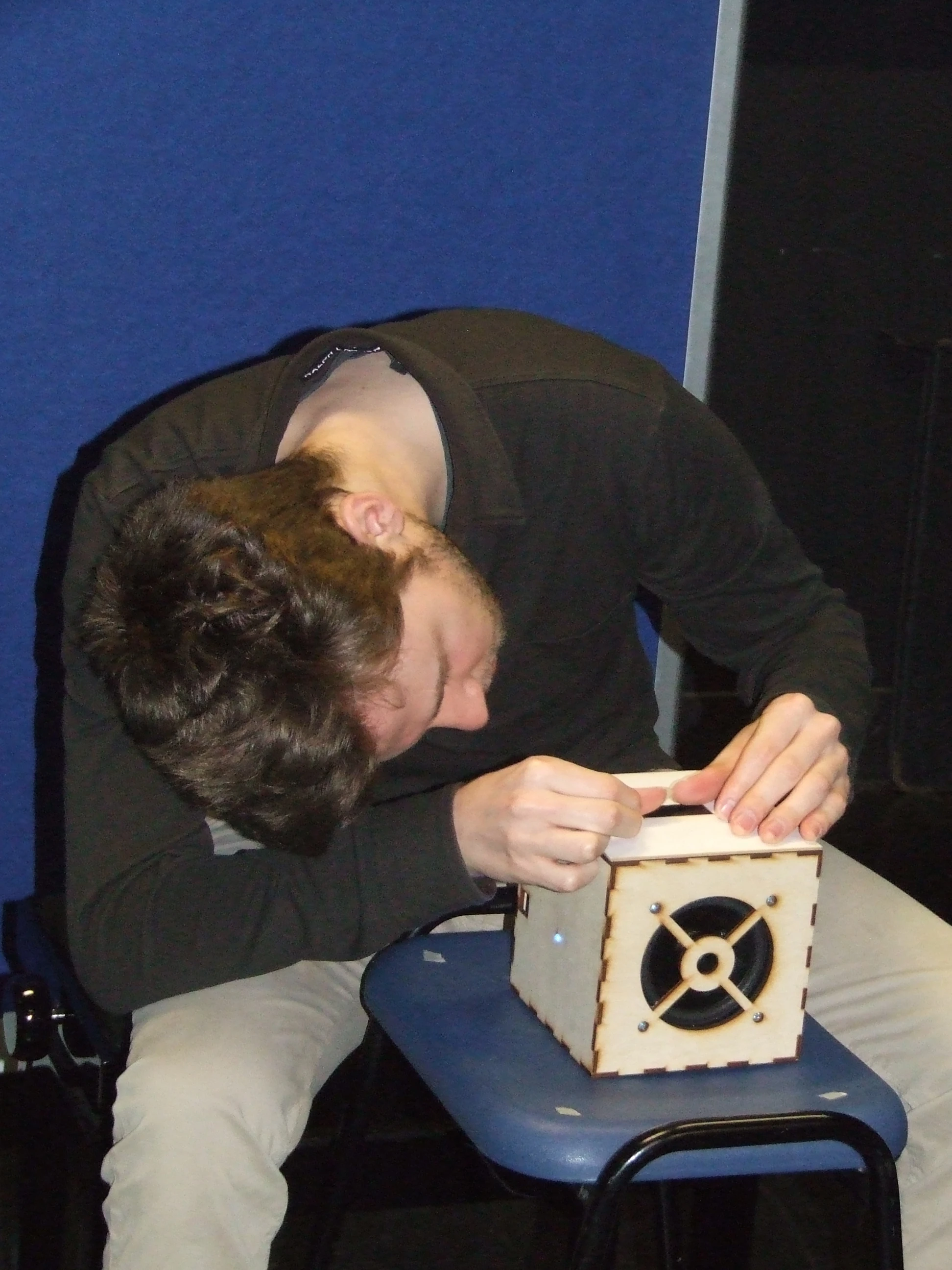 The 8-inch wooden cube comprises a two-dimensional capacitive touch sensor strip with a force-sensing resistor underneath on one of the cube's faces, and an output speaker on another