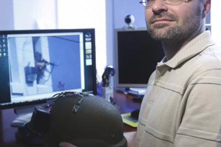 Akos Ledeczi holds a kevlar helmet with the microphones and network node attached that can turn the helmet into an accurate shooter location systemPhoto credit Steve Green, Vanderbilt University