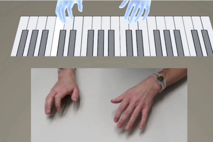 A user wearing dual TapID wristbands is able to play a virtual piano