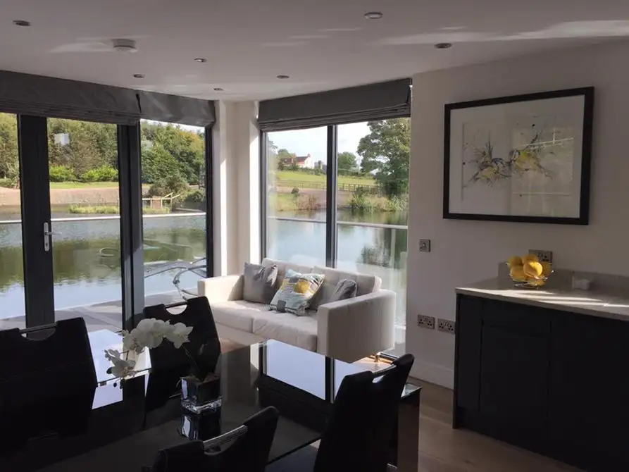 Bluefield Houseboats' interior looks quite roomy and light filled thanks to the generous glazing, and shared spaces include a lounge, dining room, and a kitchen