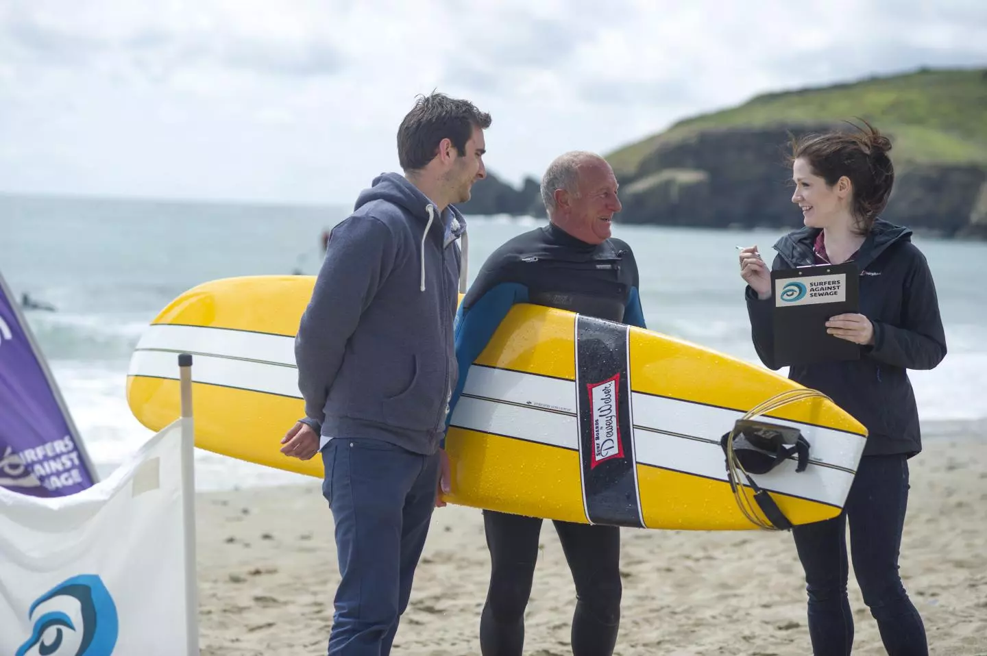 Dr. Anne Leonard interviews surfers on a beach in Cornwall, UK