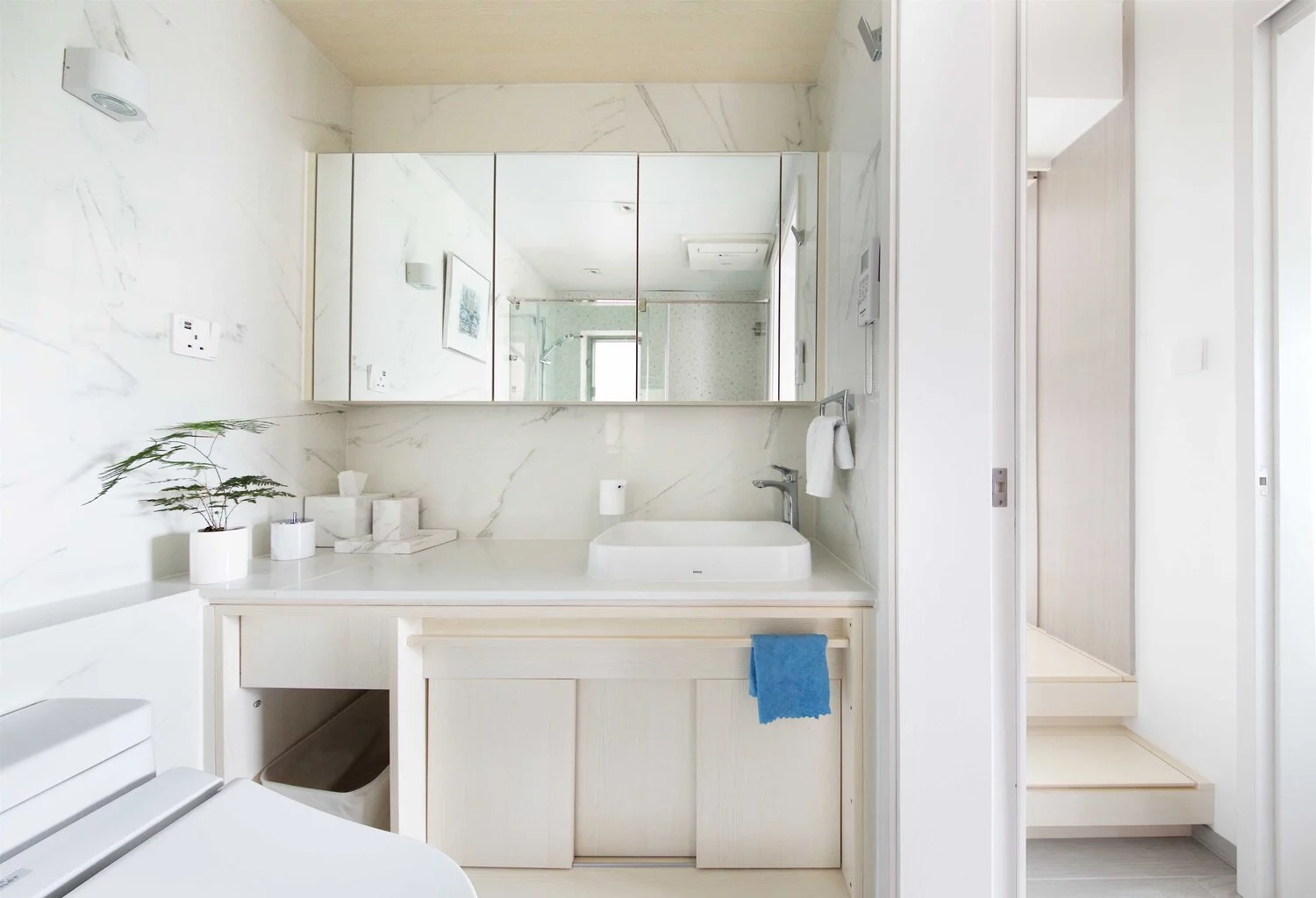 The shared bathroom features marble tiles and melamine waterproof cabinetry