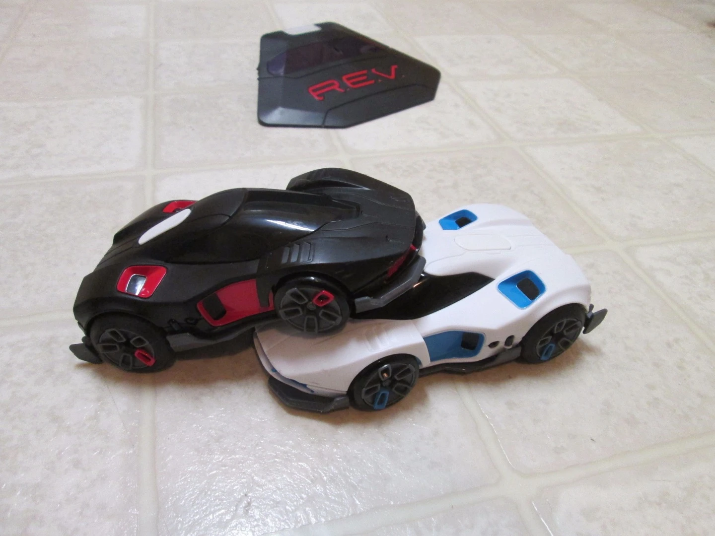 The REV cars score points by ramming one another or by hits with virtual weapons