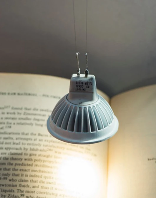 This light bulb is powered and held in place by two thin strands of carbon nanotube fibers