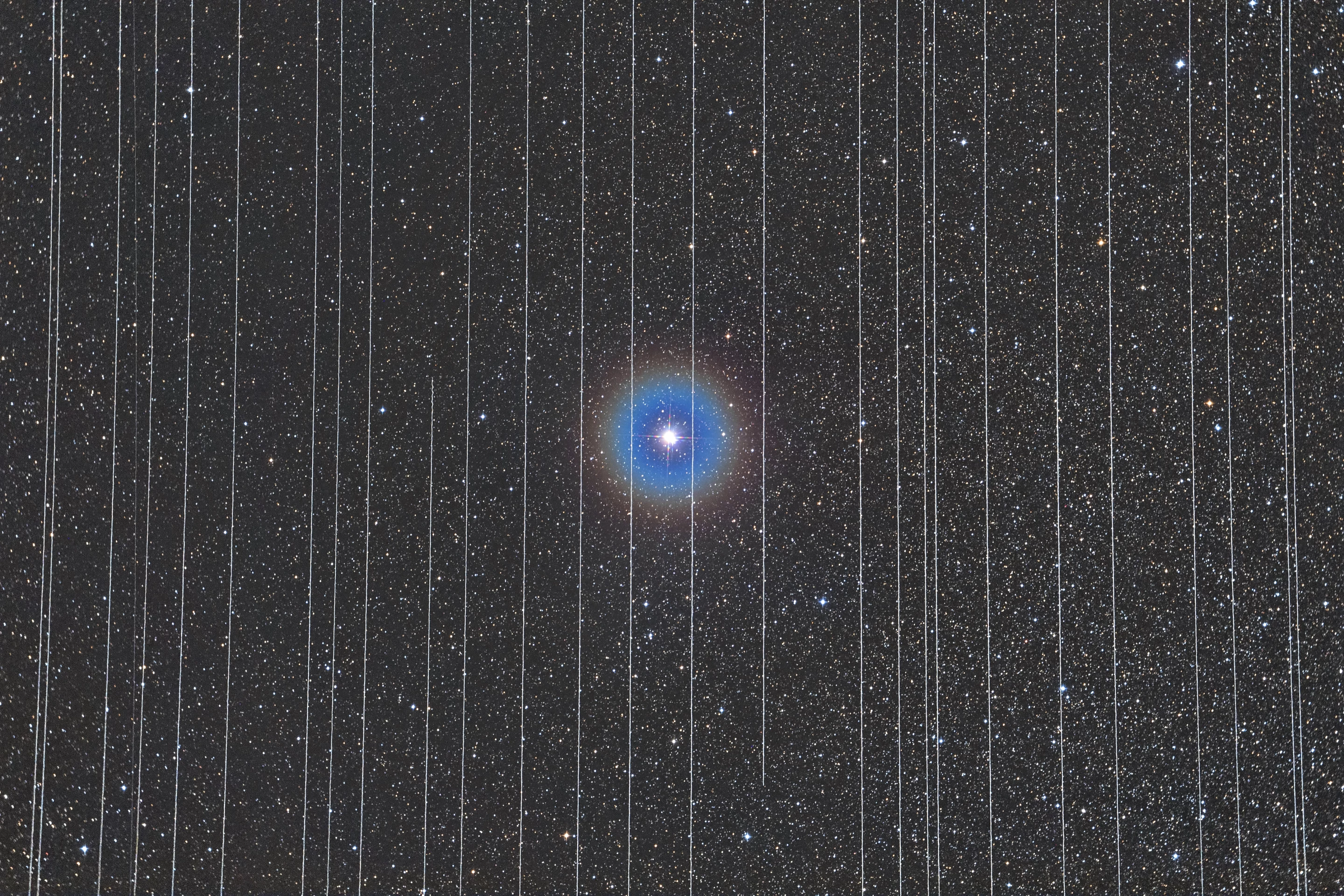 Winner - People and Space. The Prison of Technology. The star in the centre of the image is the Albireo double star, surrounded by the trails of moving satellites