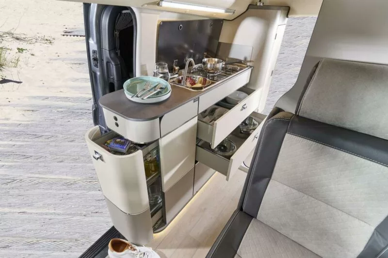 Instead of the slide-out indoor/outdoor refrigerator that some small campers have at the front of their kitchen units, the Jules Verne has a storage drawer