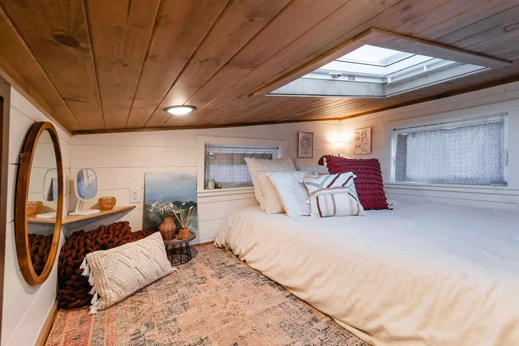 The secondary bedroom in Jen's 34' x 10' Tiny Home includes some storage space, a skylight and a bed