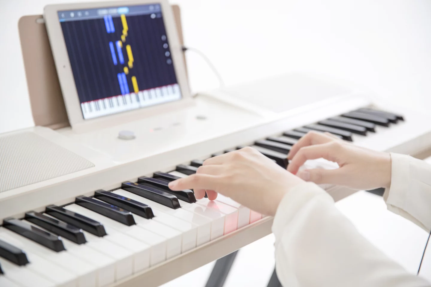 The One Light is a non-weighted digital keyboard with 61 LED backlit keys that sync with the learning app