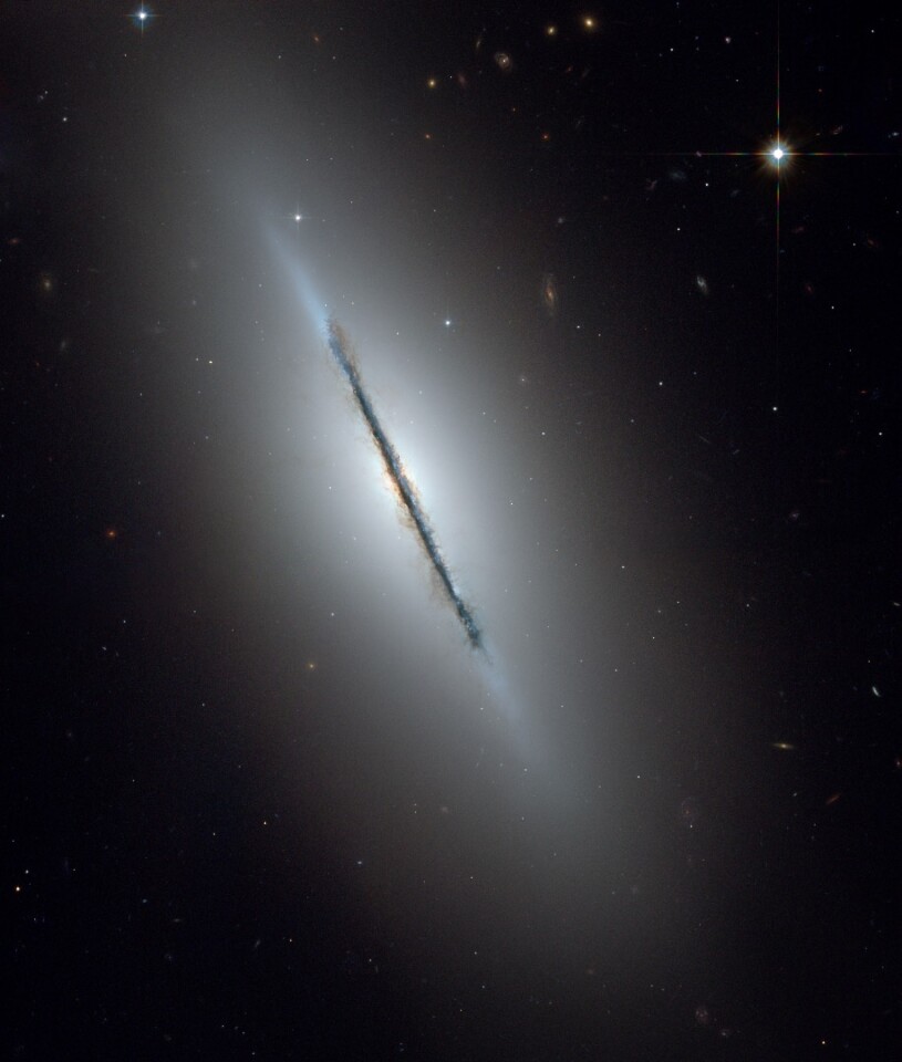 This is a unique NASA/ESA Hubble Space Telescope view of the disk galaxy NGC 5866 tilted nearly edge-on to our line-of-sight