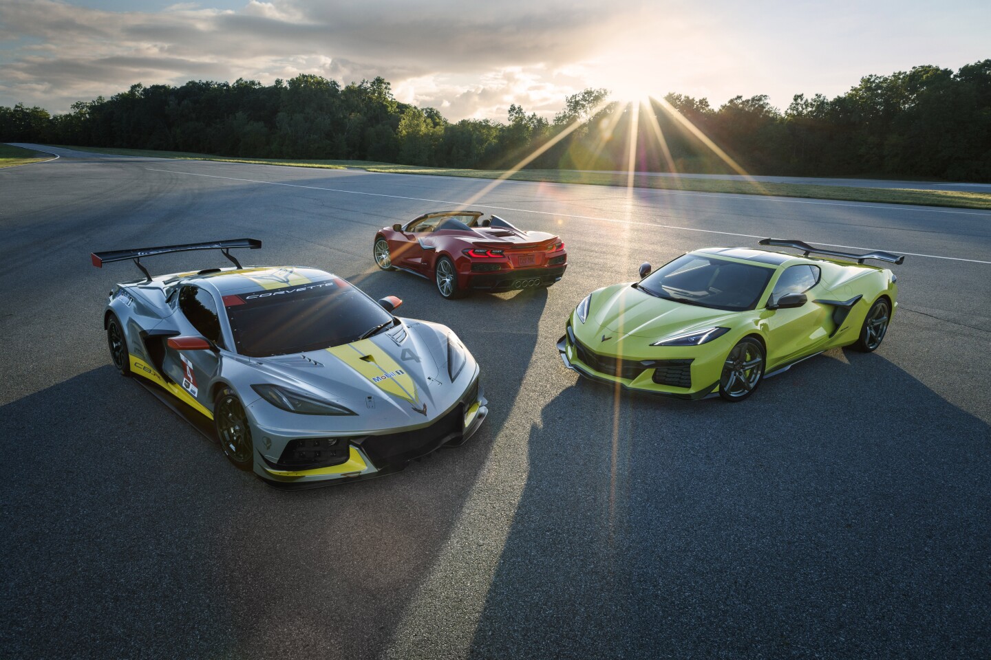The Corvette Racing C.08 (left) stands next to the production-ready 2023 Chevrolet Corvette Z06 and Z06 Convertible