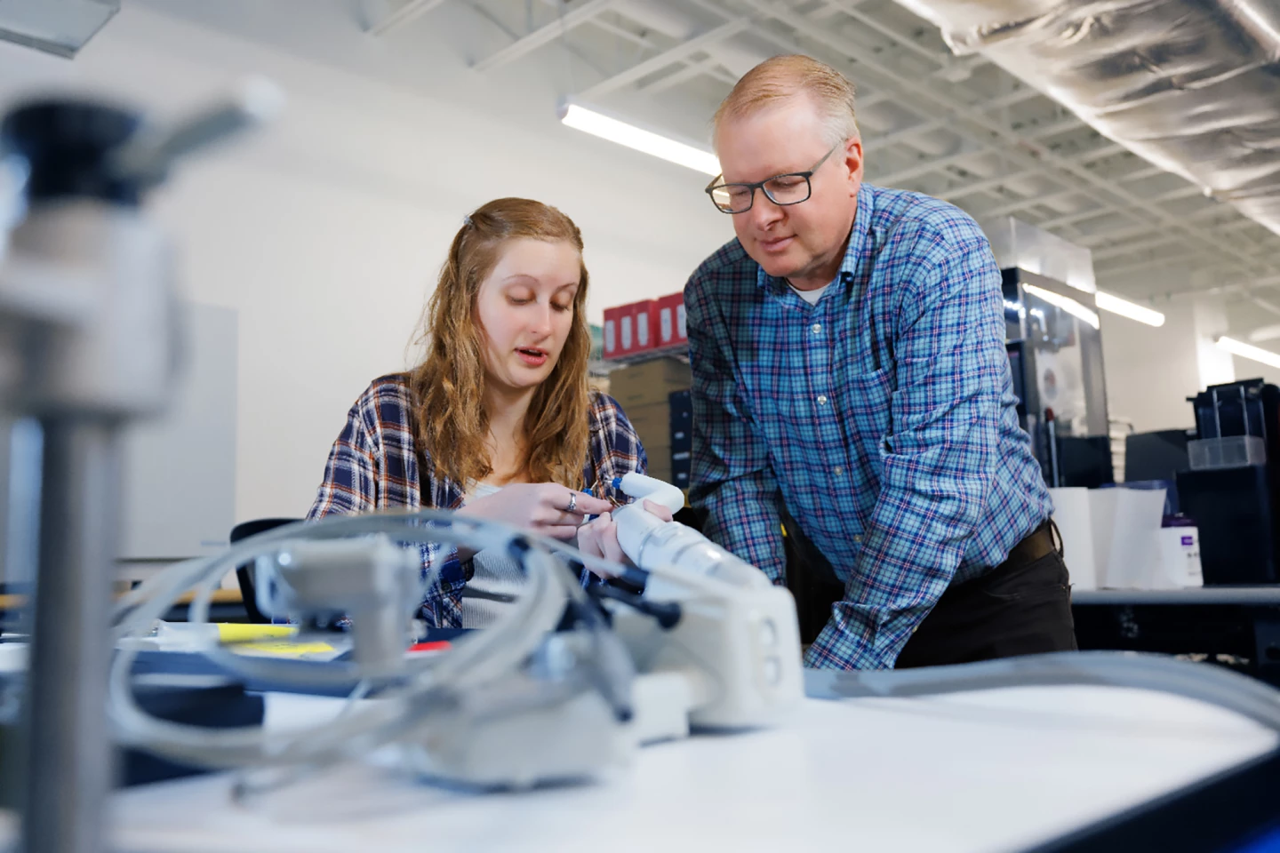 Virtual Incision employee Rachael Wagner and the company's co-founder, Shane Farrito, look over a robotic surgery device
