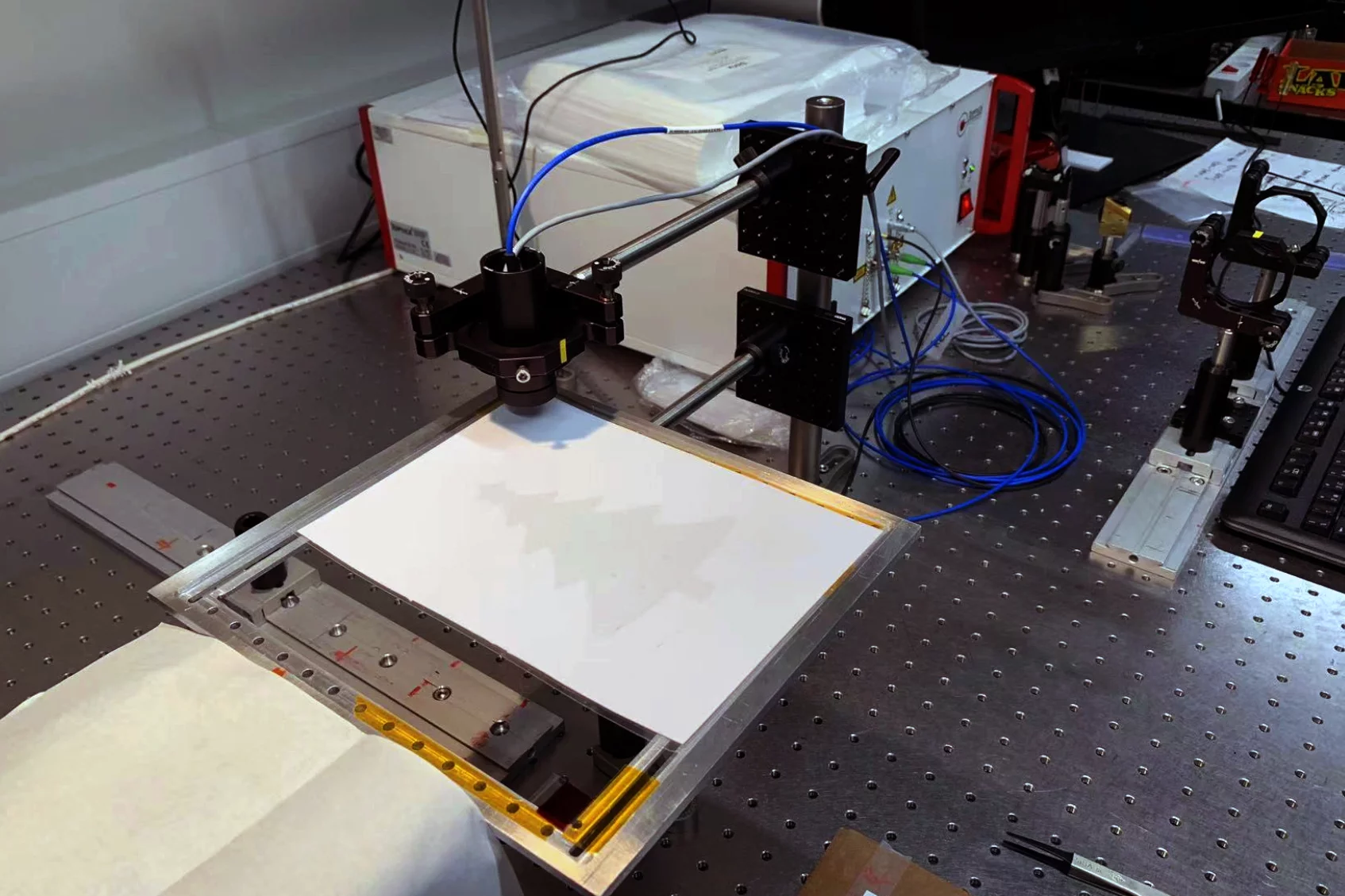 The quality-control setup, with the terahertz emitter visible above the graphene-on-polymer sheet