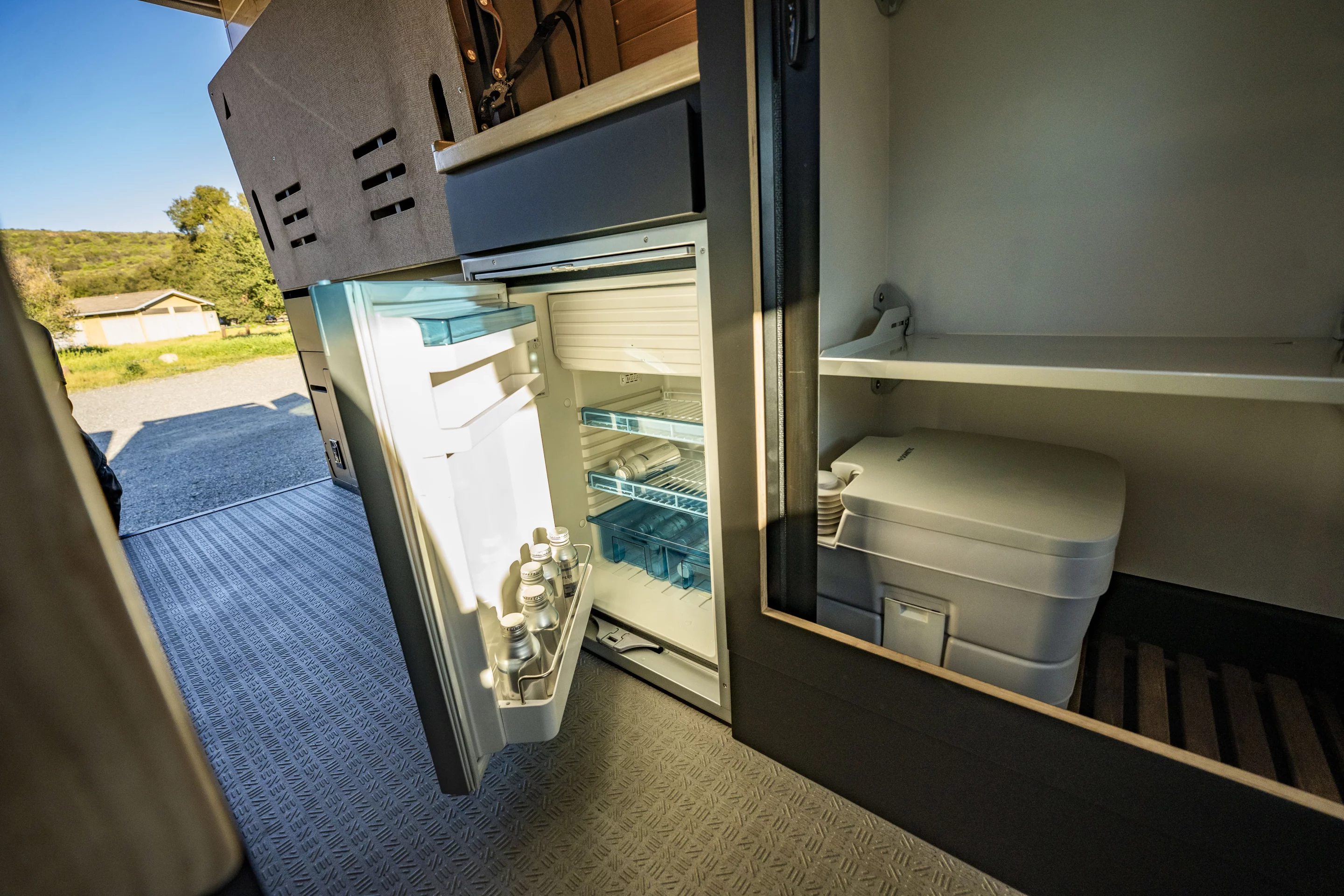 The counter-topped refrigerator gets its own space between the wet bath and Murphy bed