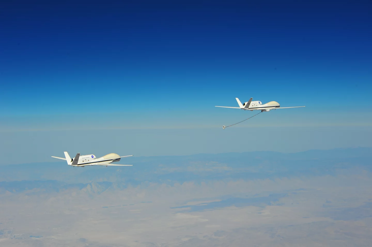 The two NASA Global Hawk UAVs flying in formation as part of DARPA's Autonomous High-Altitude Refueling (AHR) program