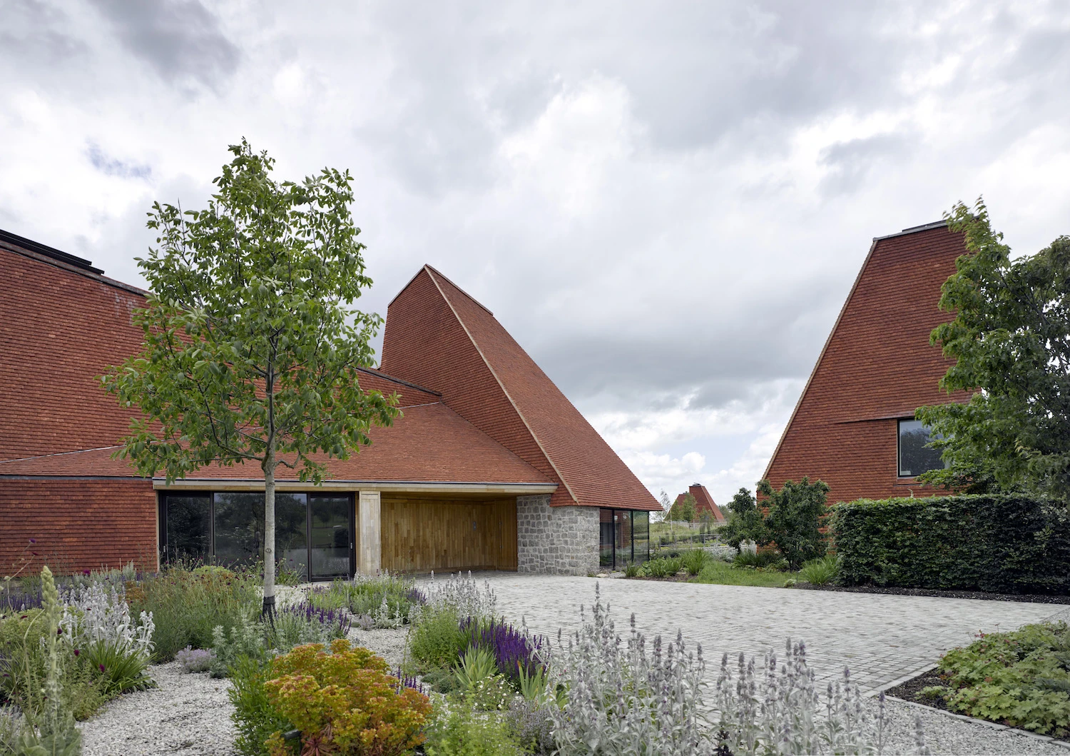Caring Wood makes good use of local handmade peg clay tiles, locally quarried ragstone and coppiced chestnut cladding