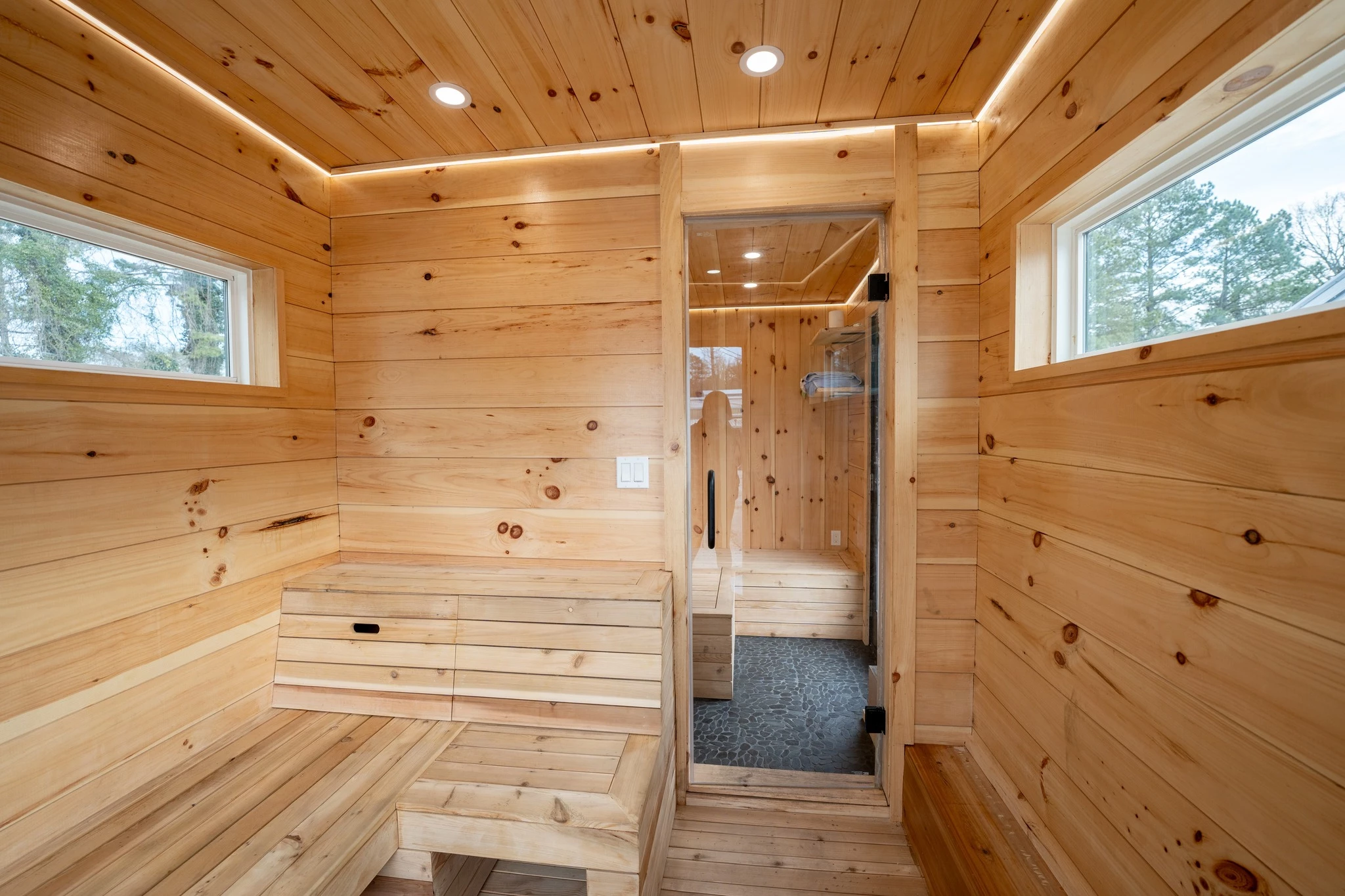 The tiny house sauna's actual sauna area is waterproof and includes a hose for cleaning it after use